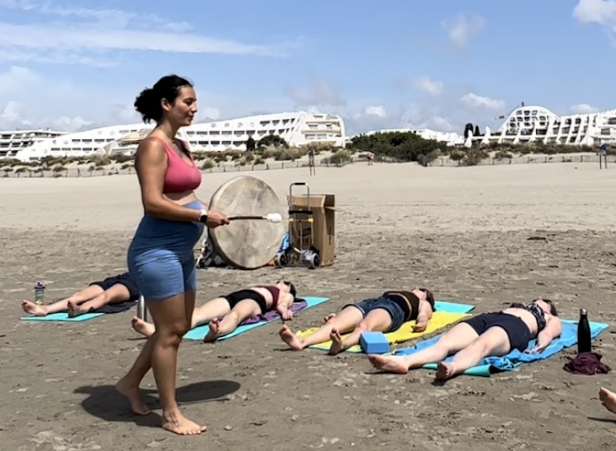 Marie-Mathilde enceinte en train d'animer un cours de yoga sur la plage
